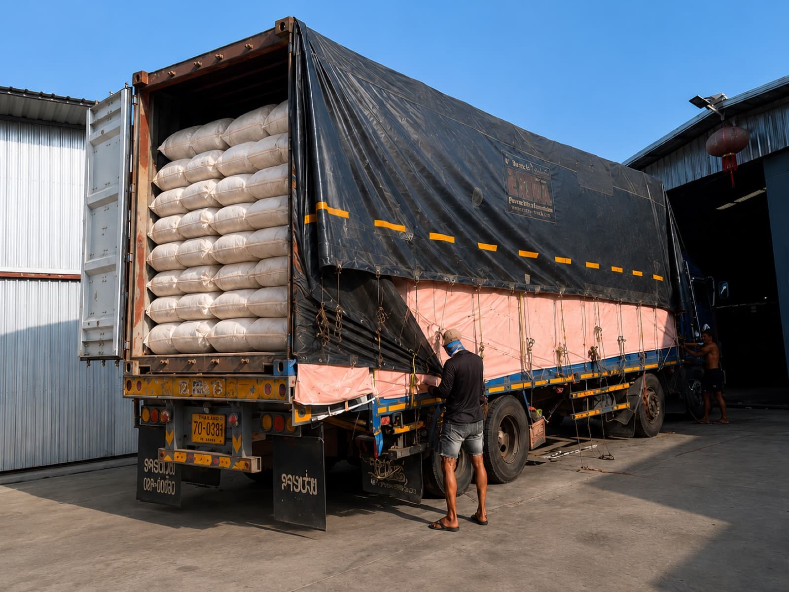 Factory team loading packed bedding products onto a truck